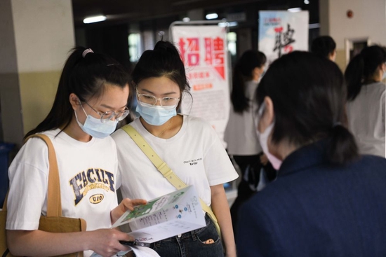 5月17日，在合肥学院内，求职者现场了解招聘信息。新华社记者张端摄