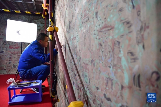 敦煌研究院文物保护技术服务中心壁画修复师杨金礼在莫高窟第231窟内修复出现病害的壁画（4月19日摄）。新华社记者 陈斌 摄