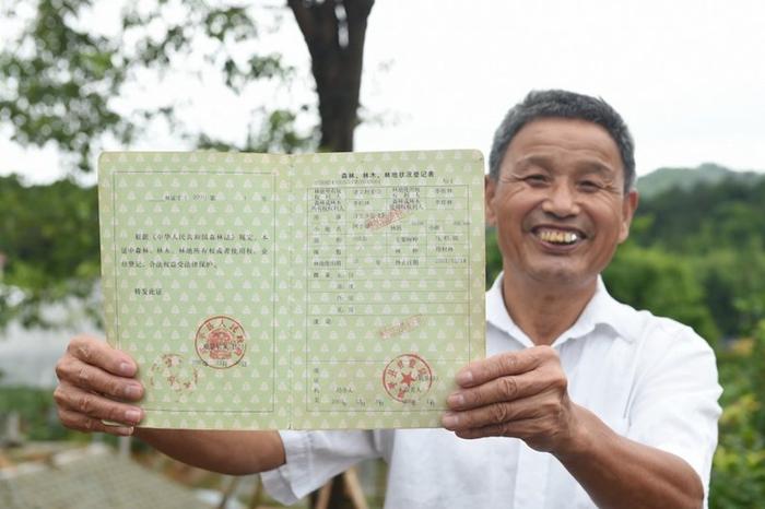 福建武平县万安镇捷文村村民李桂林展示林权改革后领到的全国第一本新式林权证。